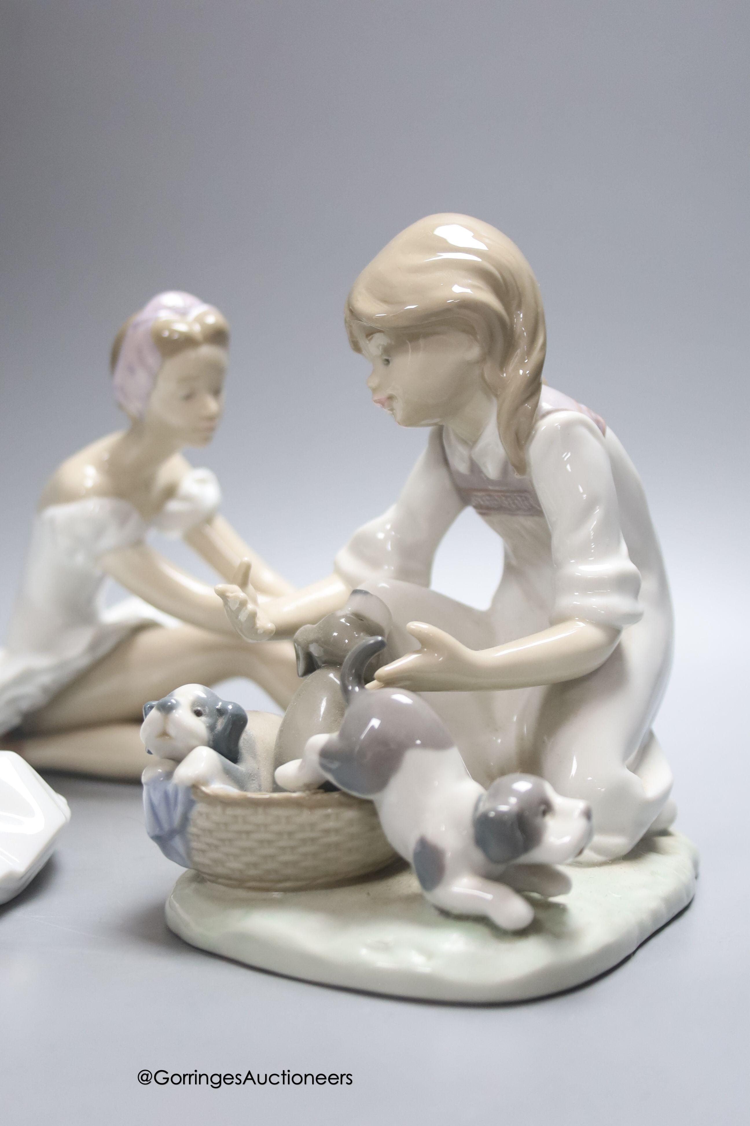 A Lladro figure of a ballerina and a child playing with dogs, height 21cm, and a Nao ballerina